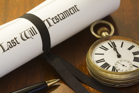 "When your time comes to an end. A scroll of a Last Will & Testament, tied with a black ribbon on a mahogany desk, with pocket watch set to midnight"