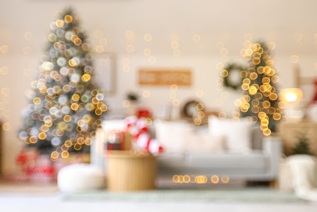 Blurred view of living room with grey sofa, Christmas tree and festive decorations